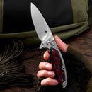 Klaken B05 Hermod J214-RedCarbonTi red marbled carbon fiber and titanium handle held in hand