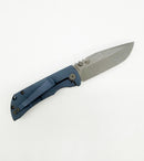 Close-up of blue titanium handle and partially open blade of folding knife