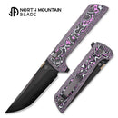 UV-reactive carbon fiber handle of the North Mountain Blade 2406-GLOWCF-DLC glowing under ultraviolet light